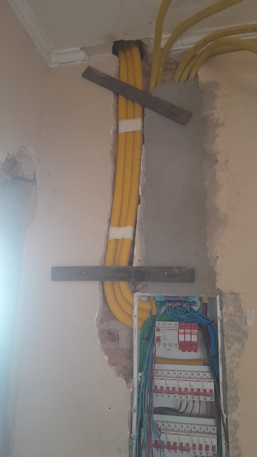 Infraestrutura elétrica com eletrodutos chegando ao quadro de distribuição durante uma obra