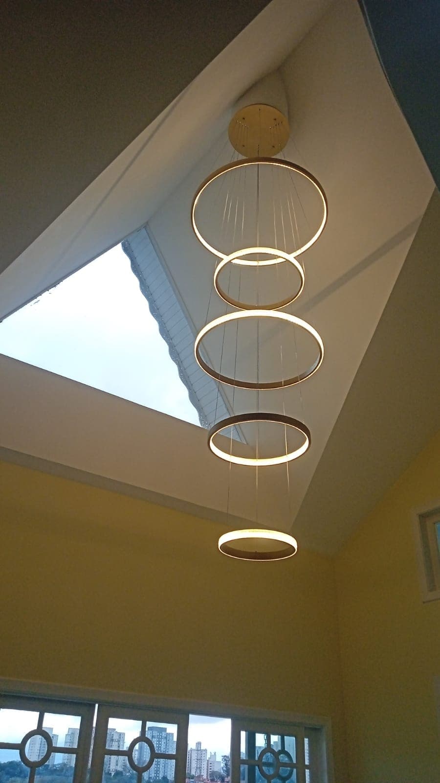 Luminária pendente de anéis em ambiente com pé-direito duplo