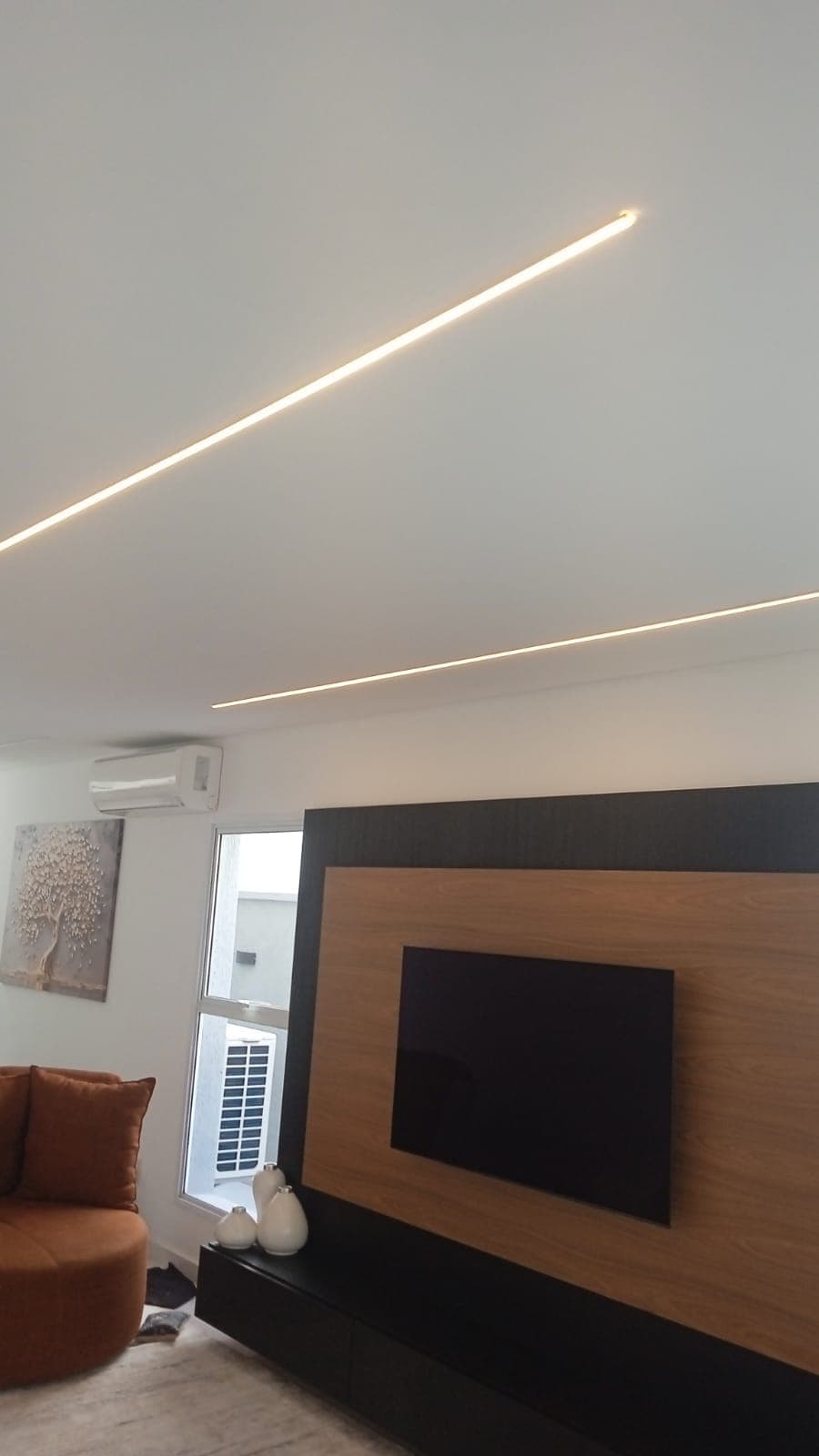 Perfis de LED no teto de uma sala de TV residencial