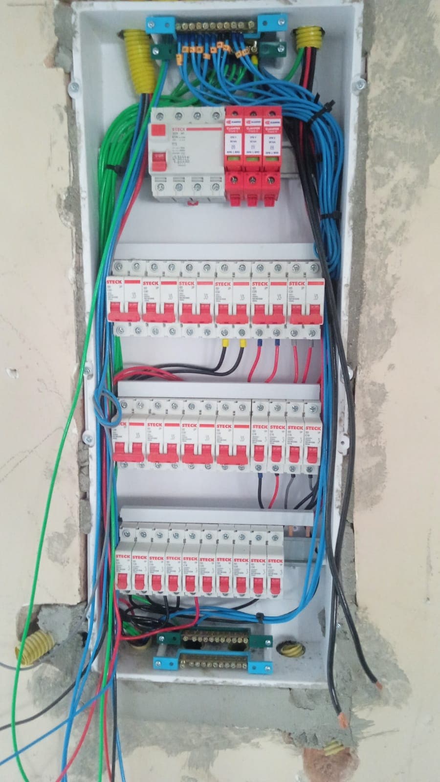 Quadro elétrico embutido durante a montagem, com barramentos e disjuntores